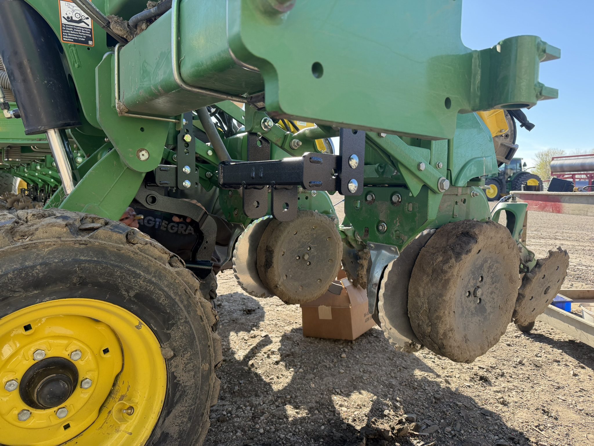 Green agricultural machinery with large metal discs.