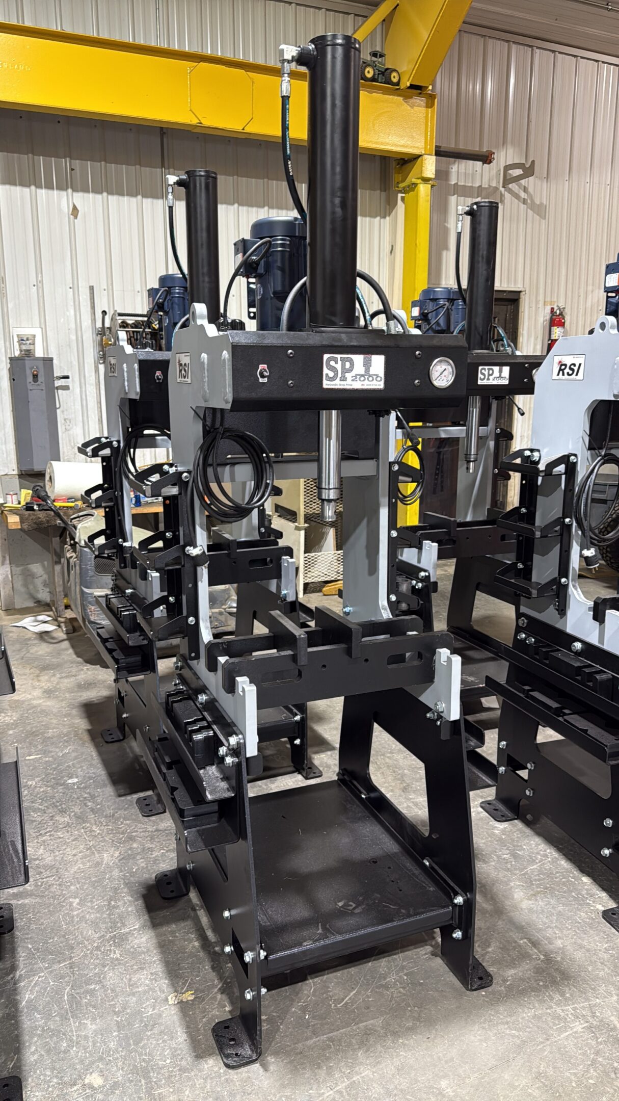 Industrial hydraulic press machine in a workshop.
